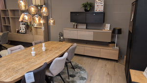 Een tafel, stoelen en kasten uitgestald in de winkel van MCB Meubelen